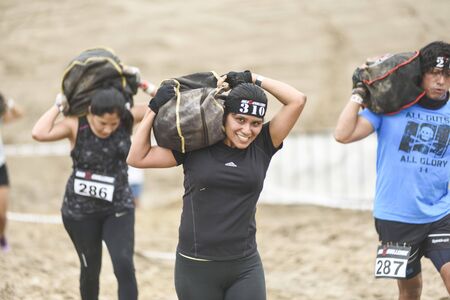 LIMA, PERU - OCTOBER 23, 2016: Inka Challenge, an extreme obstacle course where 1500 athletes from different countries managed to cross the finish line at Santa Maria beach. Young people doing their best effort.のeditorial素材