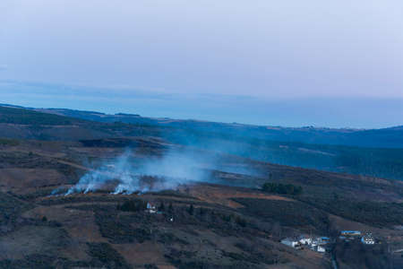 Beautiful sunset in the mountains and wildfire with smokeの写真素材