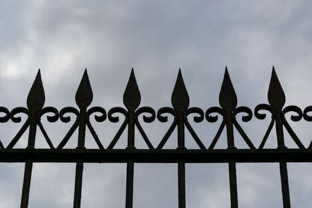 Old iron gate silhouette. Cloudy skyの写真素材