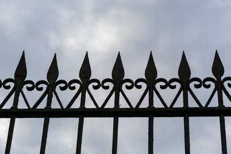 Old iron gate silhouette. Cloudy skyの写真素材