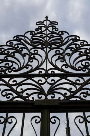 Old iron gate silhouette. Cloudy skyの写真素材