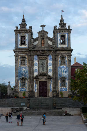 Santo Ildefonso church. Blue relegious tiles. Cloudy sky. People walkingのeditorial素材