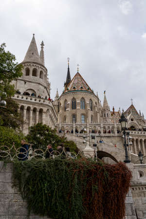 St. Matthias Church in Budapest, Hungary. Cloudy sky. Green trees.のeditorial素材