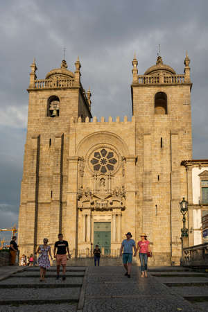 Porto Cathedral, SÃ© do Porto. Storm clouds. People walking.のeditorial素材