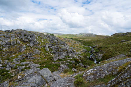 Freita mountain range highland. Rocky landscape with clouds. Hills with yellow and green vegetation. Serra da Freita, Portugalの写真素材