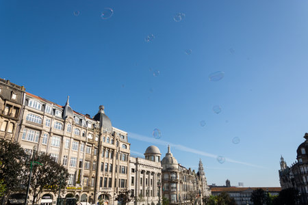 Porto, Portugal - 08/28/2019: Big soap bubbles and Porto city in the background. Aliados Avenue....