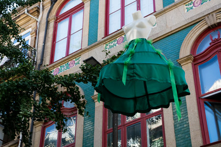 Street art exhibition. Mannequins in green dress hanging in the air. Traditional Portuguese Tiles. Porto, Portugal.の写真素材