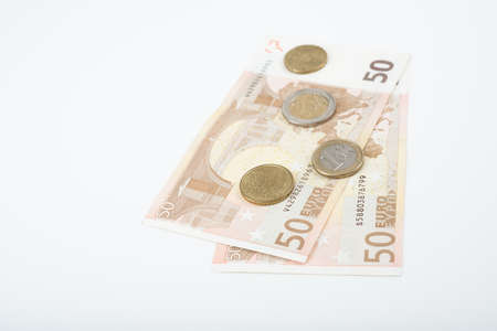 Fifty euro notes fanned back with various Euro coinsの写真素材