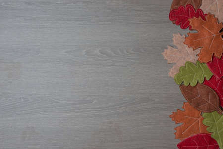 Wooden background with autumn leaves or foliage - Space for labelingの写真素材