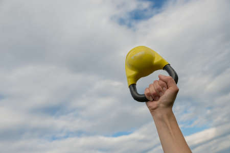 Hand with kettlebell held in the sky - confident of victory