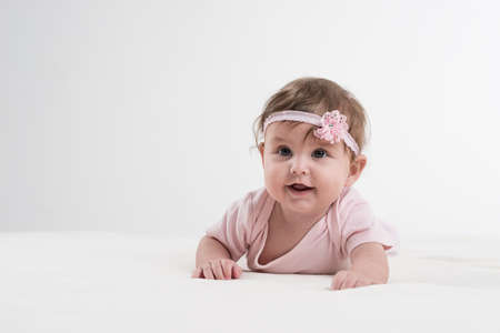 Happy baby is playing on the ground.