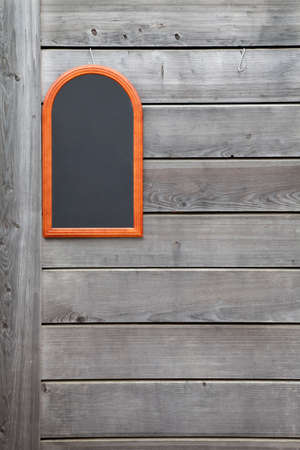 Wooden wall with a small blackboardの写真素材