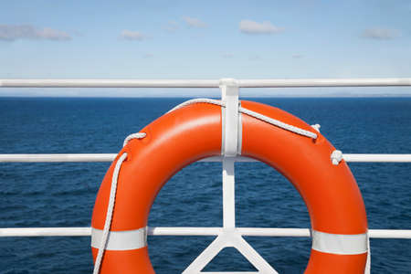 Lifebuoy and railing deck at cruise ship against seascapeの写真素材