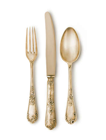 Golden cutlery set against white background with a soft shadow. Really silver pieces with ancient...