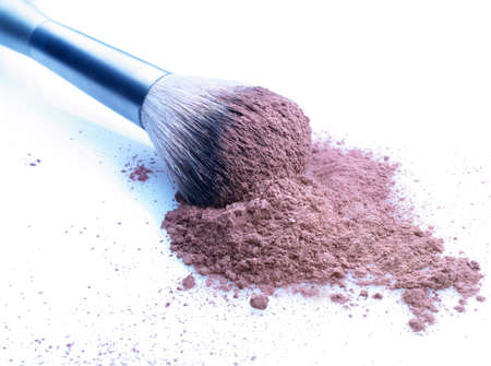 Shallow depth of field on brush and cosmetic loose powder on a stained white background. Slightly cool tonedの写真素材