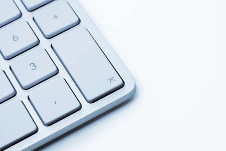 White keyboard against white background. Focus on the enter key