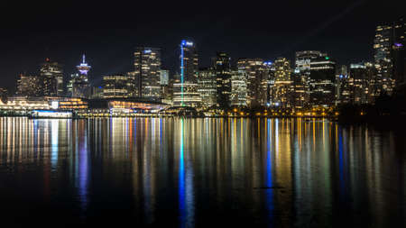 Night Vancouver with amazing reflection on the water. Beautiful colors and buildings captured from seawall Stanley Parkの写真素材