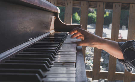 Girl playing on old piano on the beachの写真素材