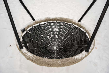 large braided bowl swing on the playground in winter timeの写真素材