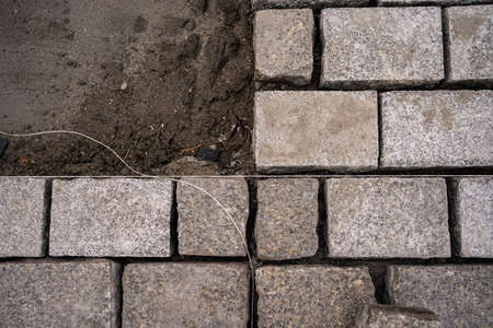Laying gray paving stones in construction siteの写真素材