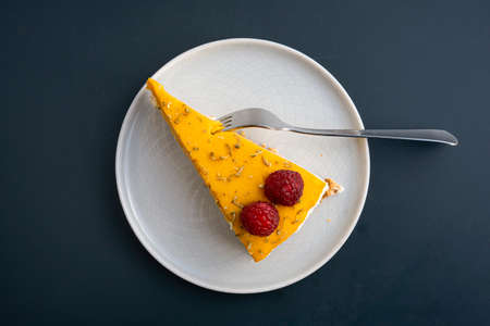 Piece of yellow cheesecake with raspberries, top viewの写真素材