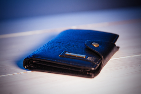 Brown leather wallet on a wooden tableの写真素材