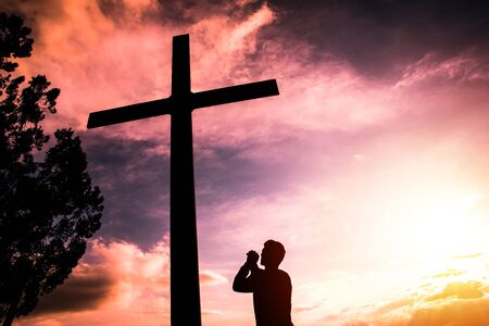 man with cross at sunsetの写真素材