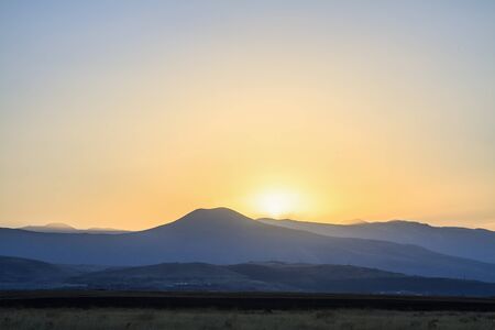 Sunset landscape field and mountains.の写真素材