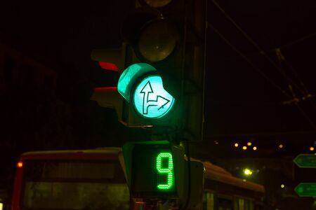 Traffic light with green arrows at nightの写真素材