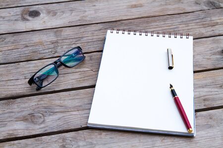Sketchbook with a pen and glasses