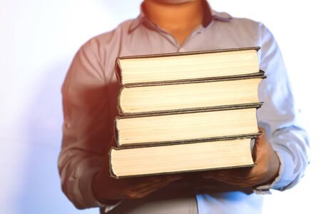 Man holding a pile of old books.の写真素材