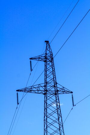 Electric high voltage tower with electric line against clear blue skyの写真素材