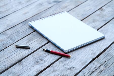 Open Blank Page notebook and pen on a rustic wooden desk. 