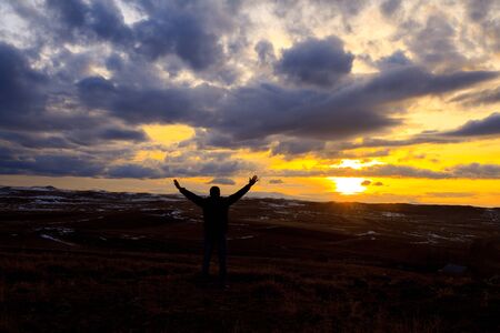 A man show hands at sunset timeの写真素材