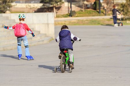 Kids with roller skates and bike. の写真素材