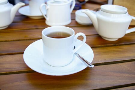 A cup of tea with teapot on a wooden tableの写真素材