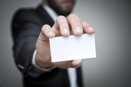 Businessman holding out a blank business card. の写真素材