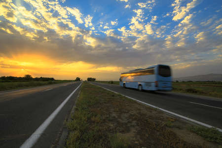 Bus moving on high-speed highway at sunset.の写真素材