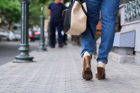 Woman walking towards on the road side.