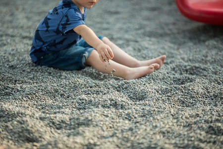 Close up little boy playing with the sand in the seashore. の写真素材