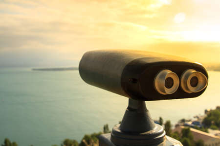 Tourist telescope with the scene of lake on sunset.の写真素材