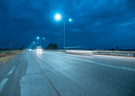 Night highway with few cars and lights.の写真素材