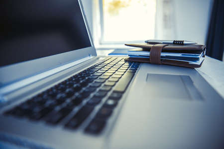 Office desk table with laptop computer and leather notebook.の写真素材