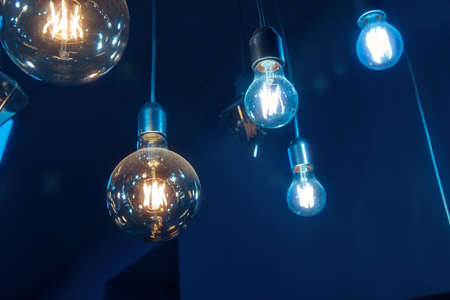 Beautiful vintage luxury light bulb hanging decor glowing in dark.の写真素材