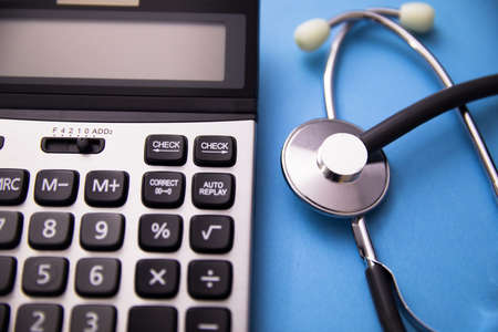 Stethoscope and calculator on tableの写真素材