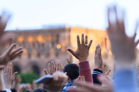 Crowd of united people hands up in the city center.の写真素材
