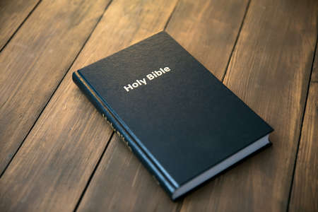 Bible with notepad and pen on table