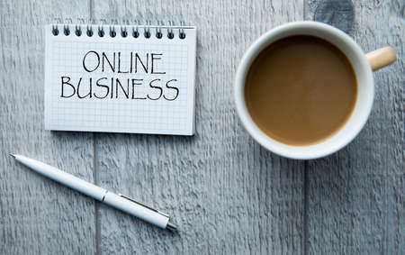 Online business text on notepad with coffee on tableの写真素材