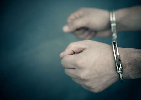 man hand handcuffs on dark background