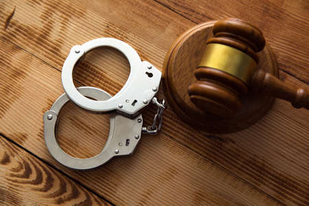 handcuffs with judge on wooden tableの写真素材